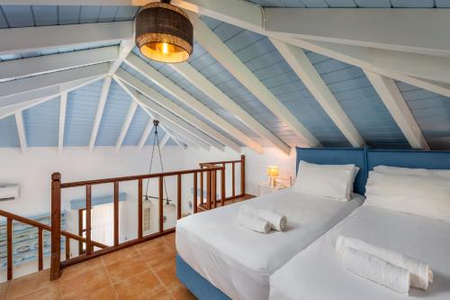 a bedroom with a bed with white sheets and pillows at Villa Ftenagia in Halki