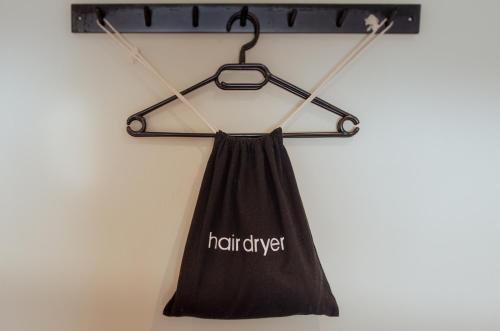 a black halter dress hanging on a wall at Seven Stars Penryn in Penryn