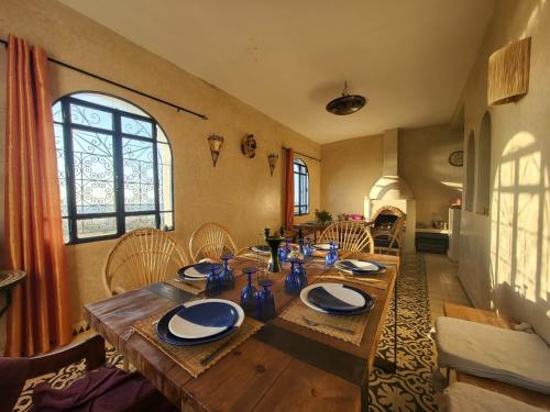 a wooden table with chairs and a dining room at Dar janoub in Aït Raïs Aomar