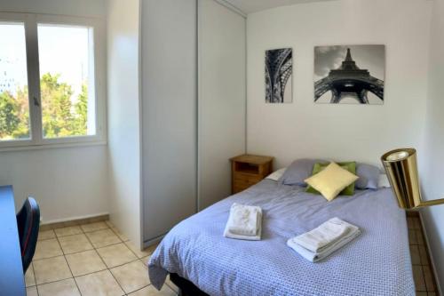 une chambre avec un lit avec deux serviettes dessus dans l'établissement Appartement Cosy Mérignac centre proche Tram, Parking, à Mérignac