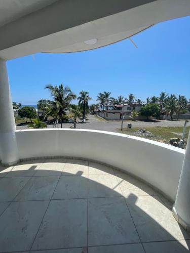 a view from the balcony of a building with palm trees at Hotel Oasis Cuyutlan in Cuyutlán