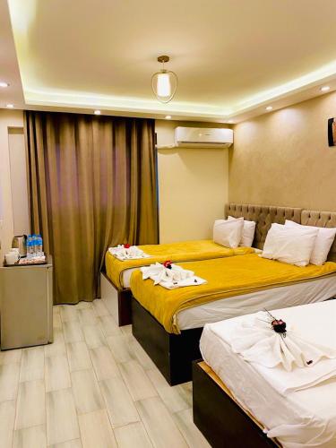 a hotel room with two beds with towels on them at Venus Pyramids-Guest House in Cairo