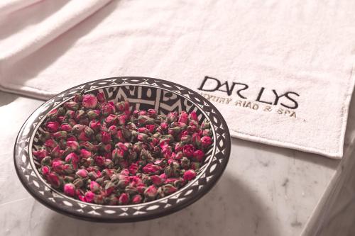 a bowl filled with pink flowers on a table at Dar Lys Luxury Riad & Spa in Fès