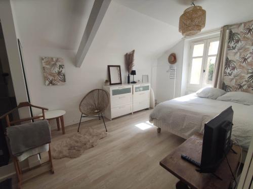 une chambre avec un lit, un bureau et une télévision dans l'établissement Logement hyper centre et près de la plage 1er étage, à Biarritz