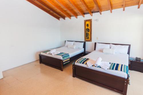 two beds and a couch in a room at Hotel Guatatur in Guatapé