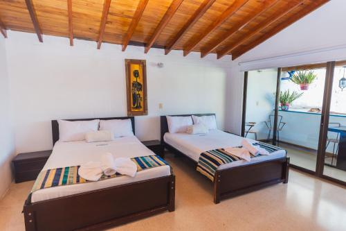 a bedroom with two beds with bows on them at Hotel Guatatur in Guatapé