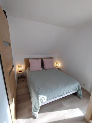 - une chambre avec un lit et 2 oreillers roses dans l'établissement Esvres - Studio au calme, à La Hardellière