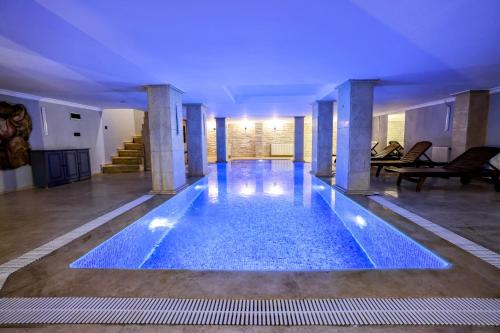 a large swimming pool in a building with blue lighting at Boğaz Manzaralı Havuzlu Lüks Villa in Istanbul