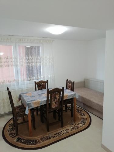 a dining table and chairs in a living room at Vila SaniMar in Ćuprija