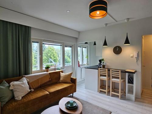 a living room with a couch and a kitchen at City Apartment Aarneenkallio & free parking in Kuopio