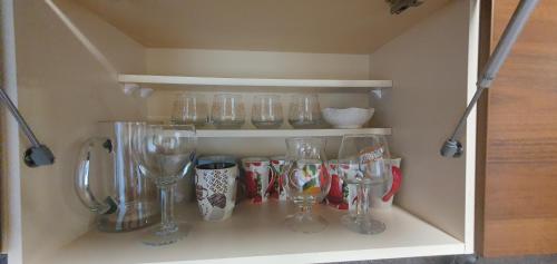 a shelf with several wine glasses on it at Cozy house with sauna and terrace in Narva-Jõesuu