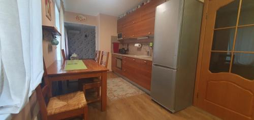 a kitchen with a refrigerator and a table in it at Cozy house with sauna and terrace in Narva-Jõesuu