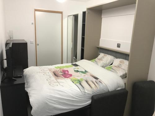 a bedroom with a white bed with a flower on it at 6 Next To Paris in Montreuil