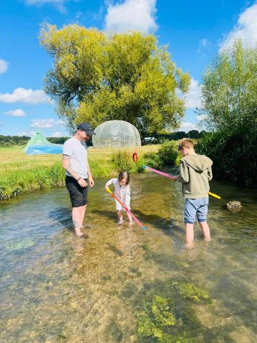 a man and two children playing in the water at Hertford Farm riverside camping firepit bbq in Hertford