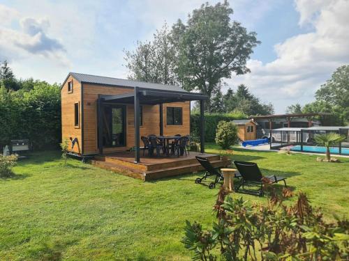 une petite maison dans une cour avec une piscine dans l'établissement l'escale de Normandie, à Saint-Martin-au-Bosc
