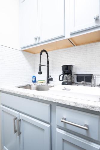 a kitchen with white cabinets and a sink at G O G Building in Darby