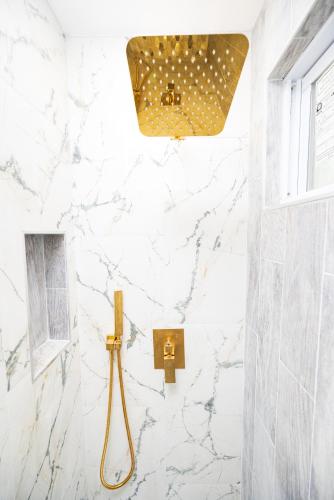 a bathroom with white marble walls and a shower stall at G O G Building in Darby