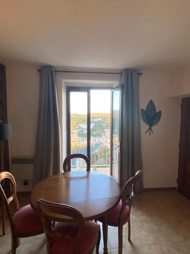 une salle à manger avec une table et des chaises et une fenêtre dans l'établissement Appartement 1 chambre avec vue sur le port, à Bonifacio