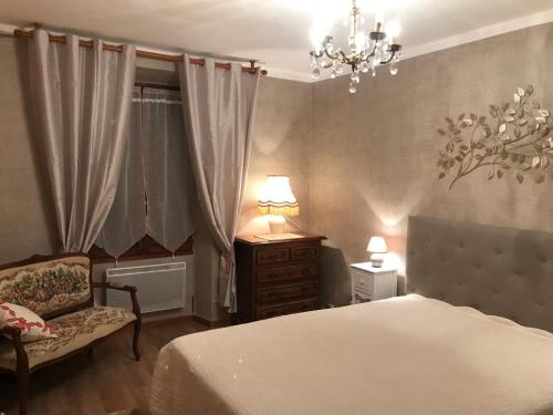- une chambre avec un lit, une chaise et un lustre dans l'établissement Appartement 1 chambre avec vue sur le port, à Bonifacio
