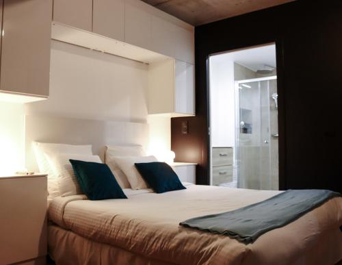 une chambre avec un grand lit avec des oreillers bleus dans l'établissement Bargue, à Paris