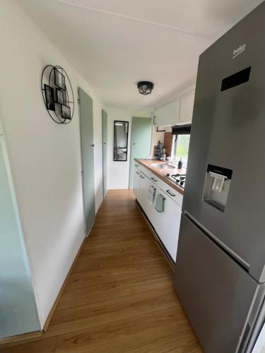 a kitchen with a refrigerator and a wooden floor at Samosiejka SPA Słońsko in Słońsko