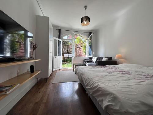 ein Schlafzimmer mit Bett und ein Wohnzimmer in der Unterkunft Superbe Studio dans villa avec entrée indépendante in Clamart