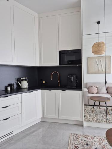 シュチェチンにあるHanza Tower 13 floorの白いキャビネットとシンクのあるキッチン