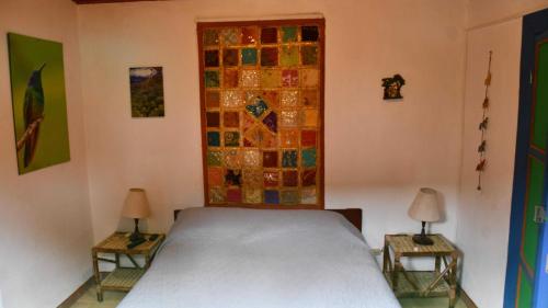 a bedroom with a bed and two tables with lamps at La Cigarra Casa de Huéspedes in Salento