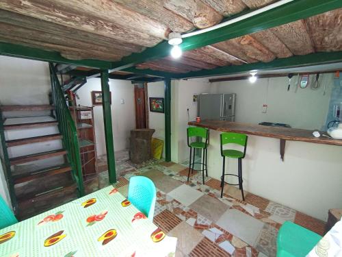 a room with a table and chairs and a kitchen at La Cigarra Casa de Huéspedes in Salento