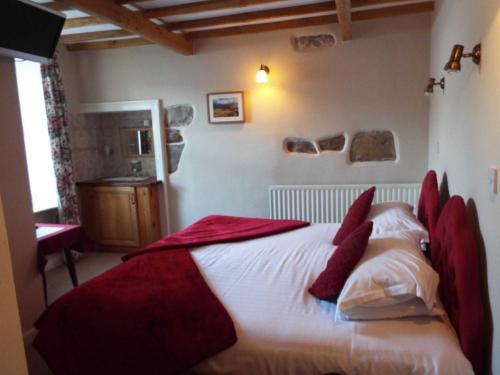 a bedroom with a large white bed with red pillows at The Board Inn in Hawes