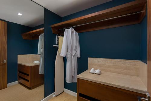 a bathroom with blue walls and a wooden vanity with white shoes at The Santa Maria, a Luxury Collection Hotel & Golf Resort, Panama City in Panama City