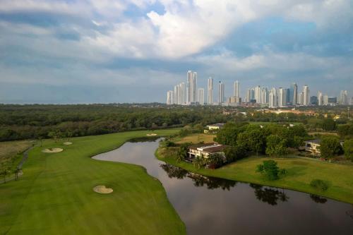 an aerial view of a golf course with a city at The Santa Maria, a Luxury Collection Hotel & Golf Resort, Panama City in Panama City