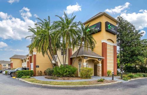 a hotel with palm trees in front of a building at Extended Stay America Select Suites - Tampa - North Airport in Tampa