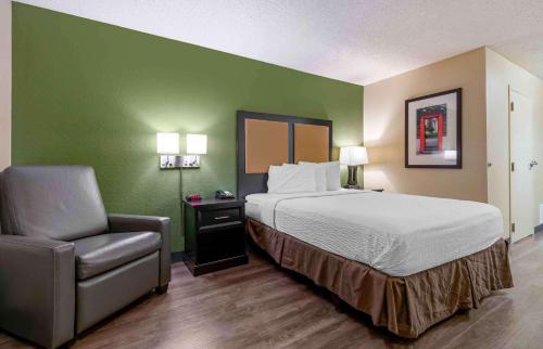 a hotel room with a bed and a chair at Extended Stay America Select Suites - St Louis - O' Fallon, IL in O'Fallon