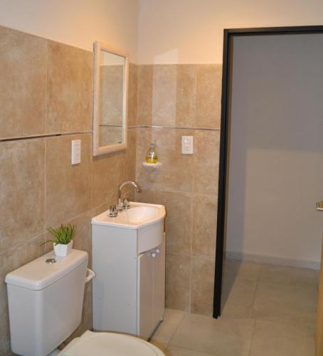 a bathroom with a toilet and a sink at Apart Los Laureles in Villa Regina