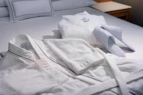 a pile of white sweaters and socks on a bed at Delta Hotels by Marriott Seattle Everett in Everett