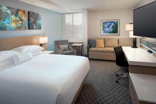 a hotel room with a bed and a living room at Delta Hotels by Marriott Seattle Everett in Everett