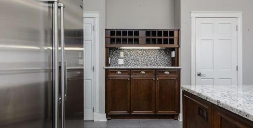 a kitchen with wooden cabinets and a refrigerator at Greystone WaterFront Lux in Saint John