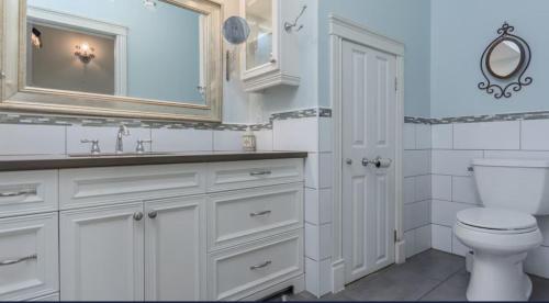 a bathroom with a toilet and a sink and a mirror at Greystone WaterFront Lux in Saint John