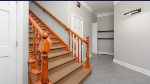a staircase with wooden railings in a home at Greystone WaterFront Lux in Saint John