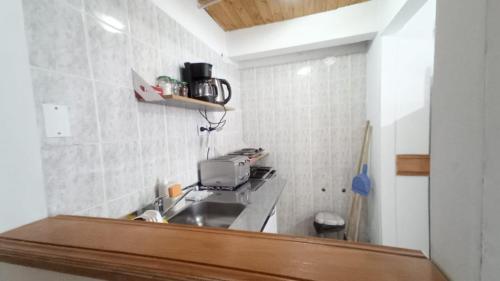 a small kitchen with a sink and a microwave at Departamentos Paisaje del Beagle in Ushuaia