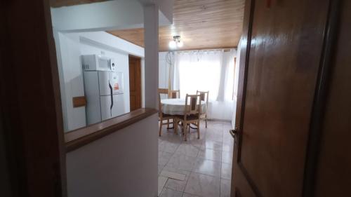 a kitchen and dining room with a table and a refrigerator at Departamentos Paisaje del Beagle in Ushuaia