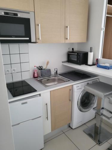 une cuisine avec un évier et une machine à laver dans l'établissement 3 Next To Paris, à Montreuil