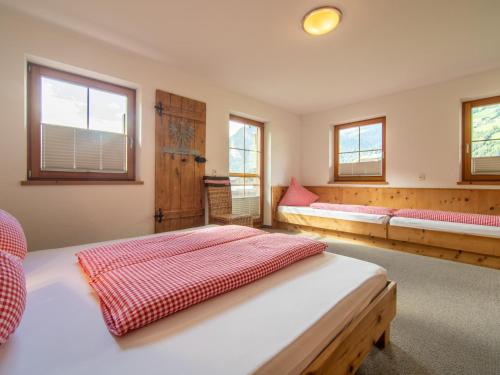 a bedroom with two beds and two windows at Blick zum Mayrhofen in Ramsau im Zillertal