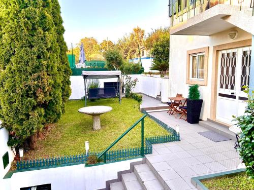 a garden with a table and a bench on a building at Casinha Margarida in Adaúfe