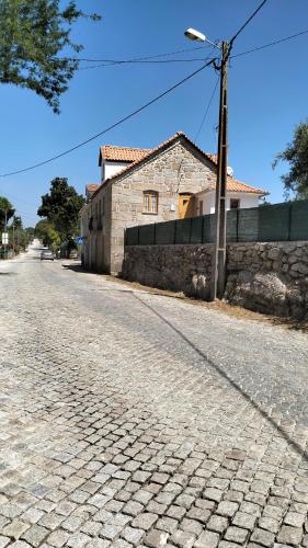 an empty cobblestone street with a stone building at Serra da Estrela - Casa Castro in Gouveia