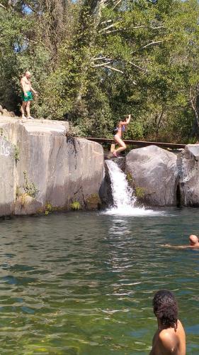 a group of people playing in the water at a waterfall at Serra da Estrela - Casa Castro in Gouveia
