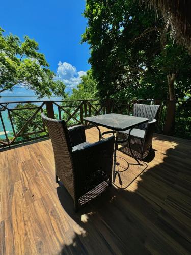 a patio with a table and chairs on a deck at Villas Mandarina Bacalar in Bacalar