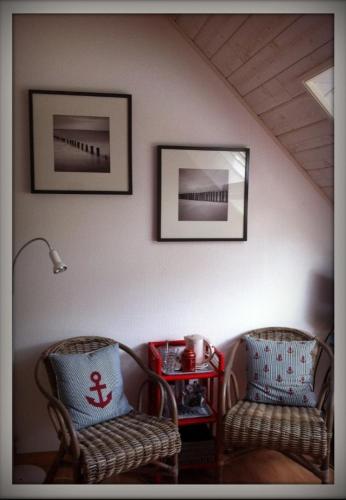 - deux chaises et une table dans le salon dans l'établissement Les Agapanthes, à Le Tour-du-Parc