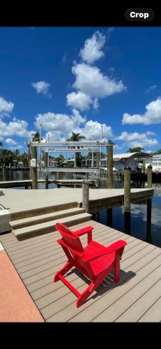 a red chair sitting on a dock near the water at Hot tub and Dock Gilligan's on the Island in Matlacha